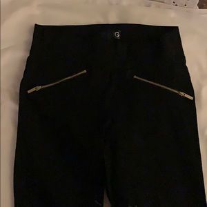 Stretch pants with gold zippers on front